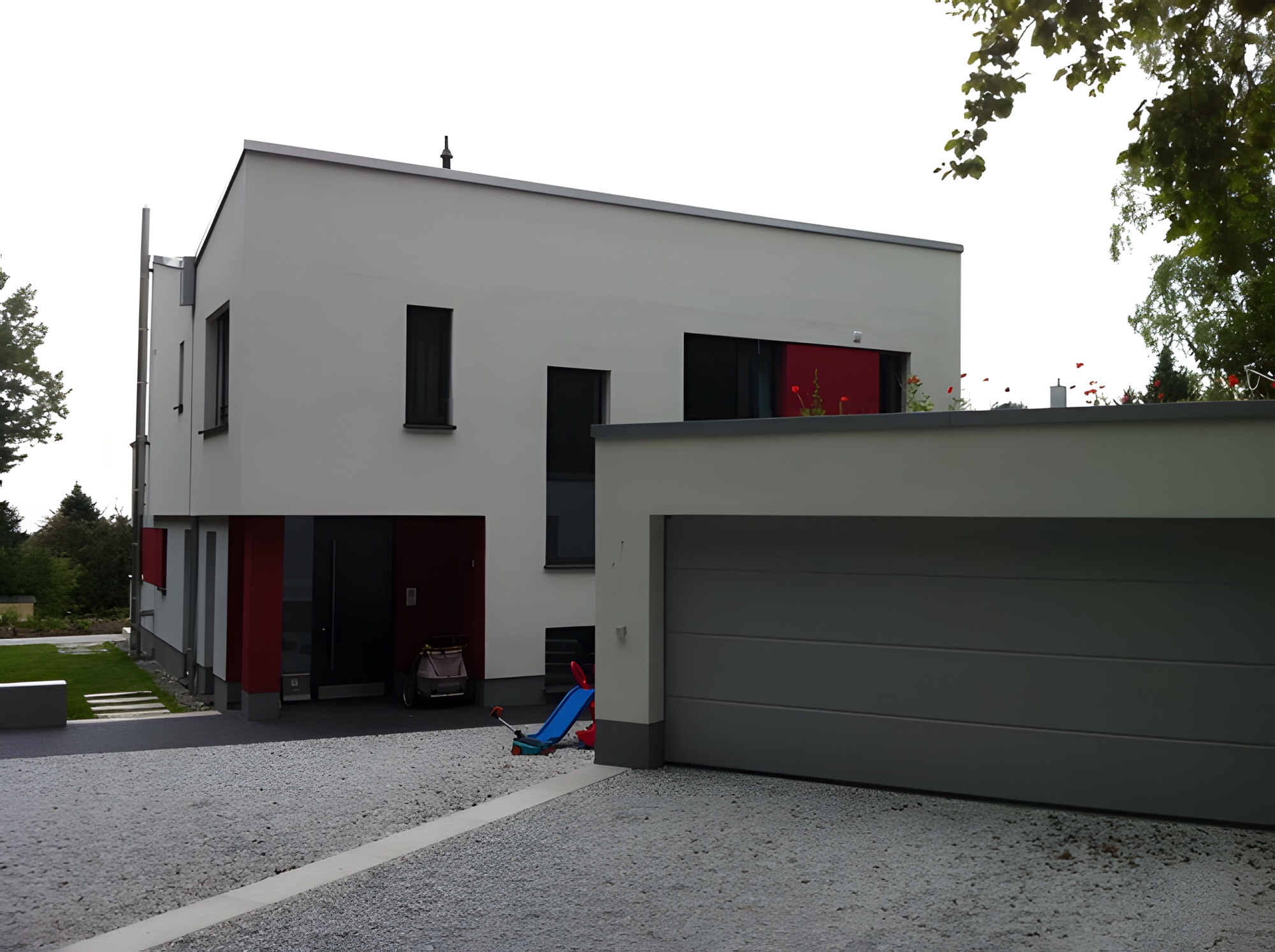 Neubau mit heller Putzfassade und roten Akzenten